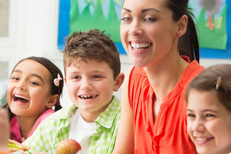 Three kids and an adult, all smiling.