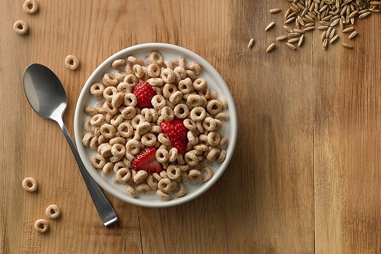 A top view of a table with a bowl of cereal.